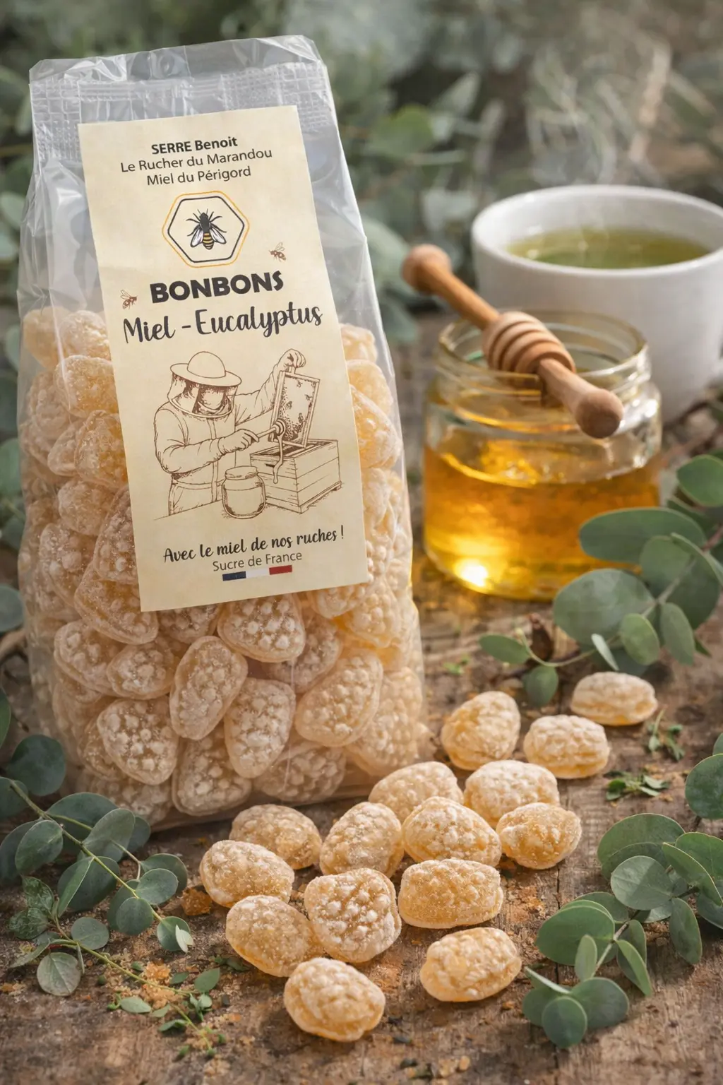 Bonbons au miel et Eucalyptus - Mise en scène gourmande Bonbons artisanaux au miel du Périgord saveur eucalyptus en sachet, présentés avec feuilles d’eucalyptus, pot de miel et tasse d’infusion