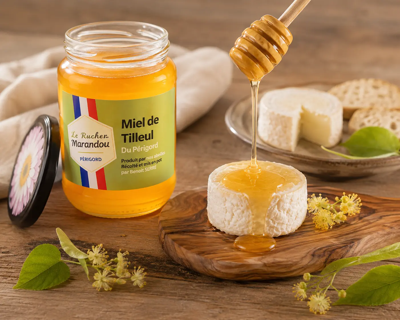 Miel de tilleul du Périgord coulant sur un cabécou avec pot de miel et fromage de chèvre