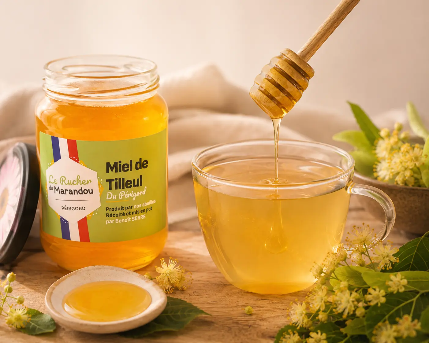 Pot de miel de tilleul du Périgord dans une infusion chaude avec miel coulant et fleurs de tilleul